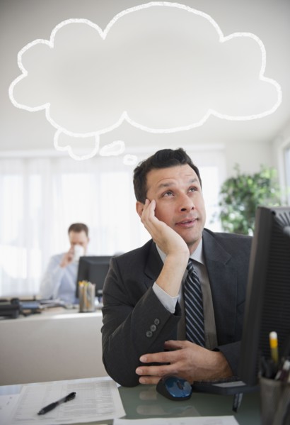 Mixed race businessman sitting under thought bubble