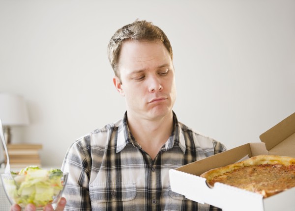 Caucasian man looking at pizza in box