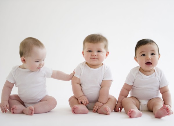 Three babies sitting on floor