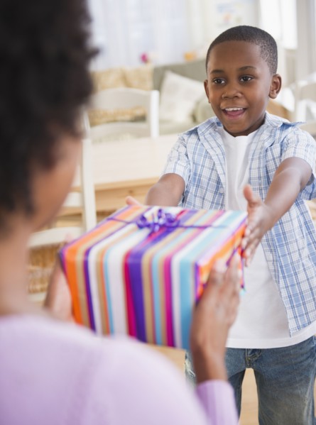Black son handing mother a gift