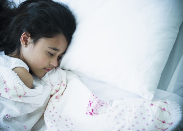 Mixed race girl sleeping in bed