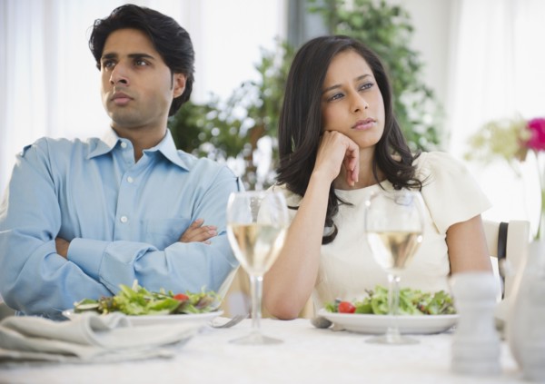 Unhappy mixed race couple dining together