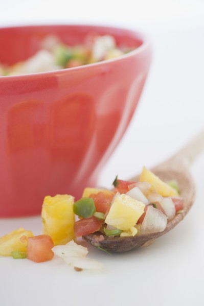 Spoonful of salsa next to bowl
