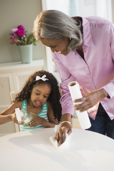 African American grandmother and granddaughter cleaning the table