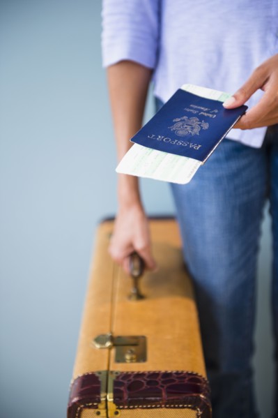 Cape Verdean woman holding passport and suitcase