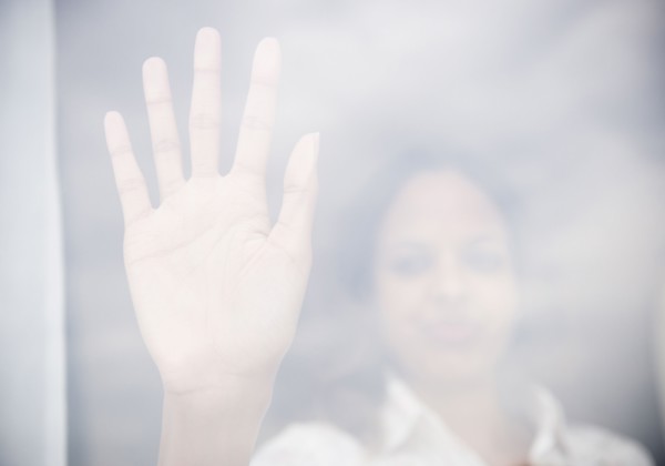 Cape Verdean woman putting hand on window