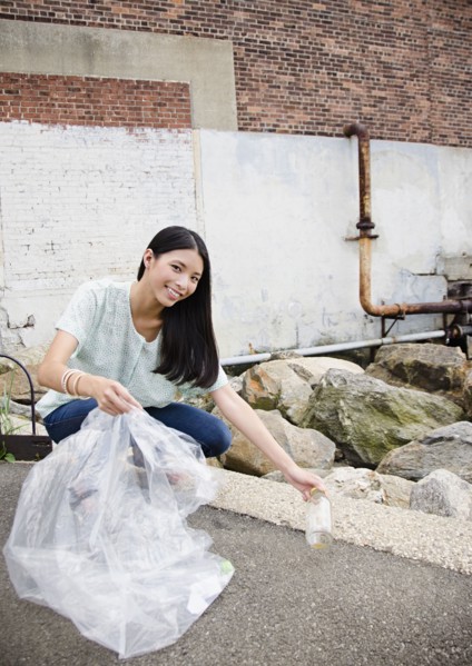 Asian woman picking up litter