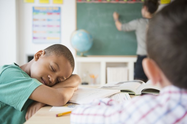 African American boy sleeping in classroom
