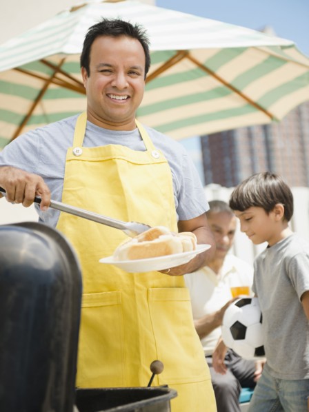 Hispanic father and son at barbecue