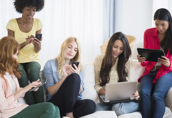 Women using technology on sofa