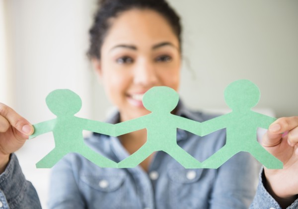 Hispanic woman holding paper dolls