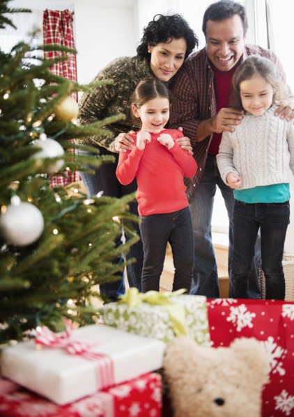 Family examining presents under Christmas tree