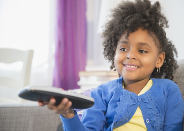 African American girl watching television on sofa