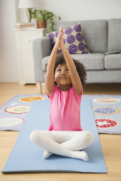 African American girl practicing yoga in living room