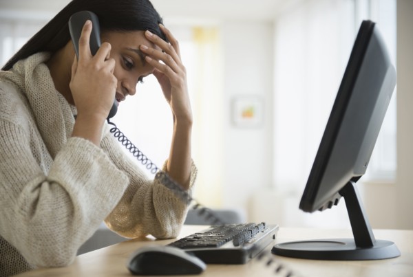Mixed race woman talking on phone at desk