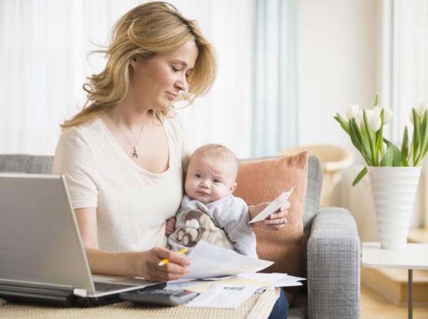 Caucasian mother with baby paying bills