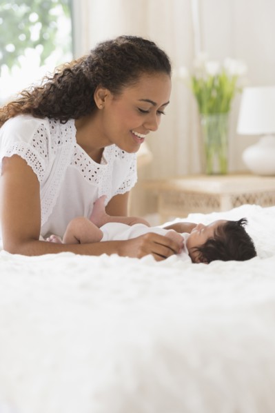 Hispanic mother playing with infant