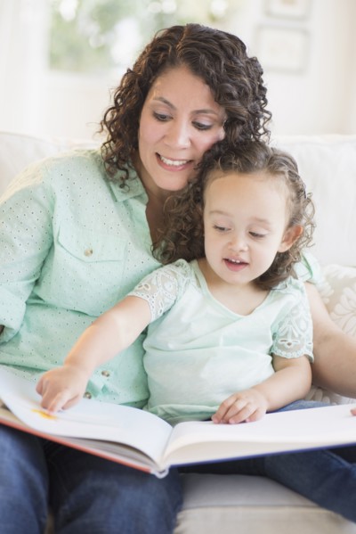 Mixed race mother reading with daughter