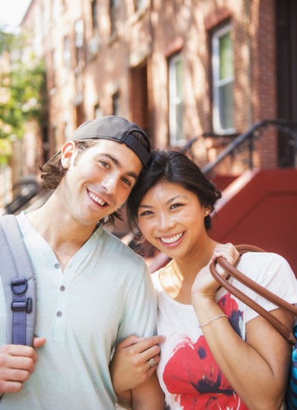 Couple smiling outside brownstones