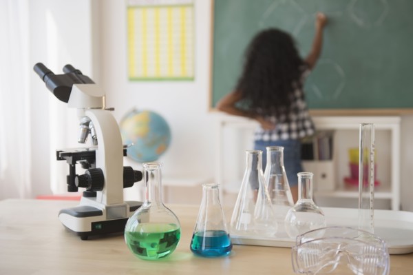 Mixed race student writing on chalkboard in classroom