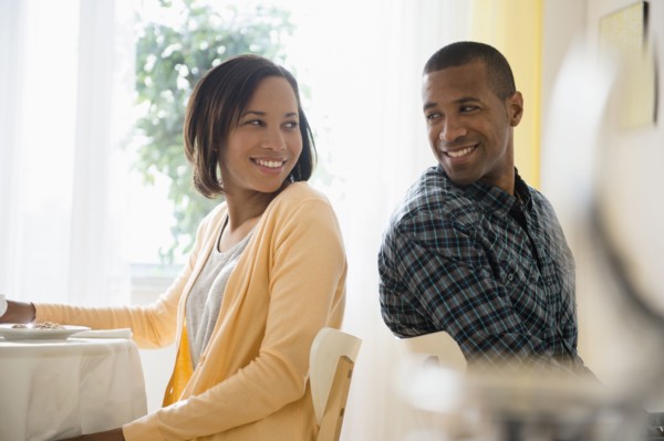Man and woman turning to smile at each other in restaurant