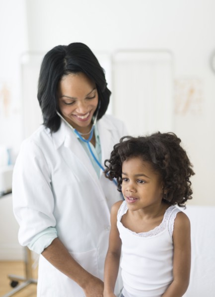 African American girl receiving checkup from doctor