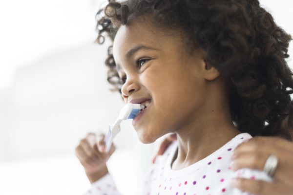 Close up of African American girl brushing teeth