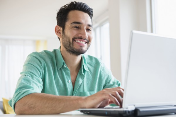Mixed race man using laptop