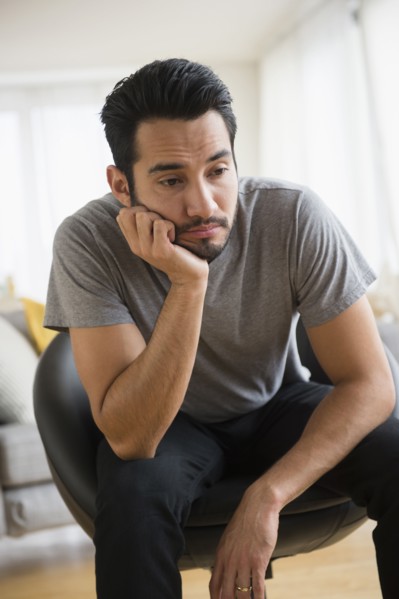 Mixed race man resting chin in hand