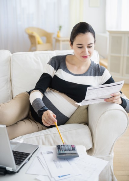 Pregnant Caucasian woman paying bills