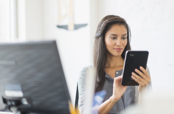 Hispanic businesswoman using digital tablet in office