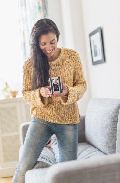 Hispanic woman using vintage camera