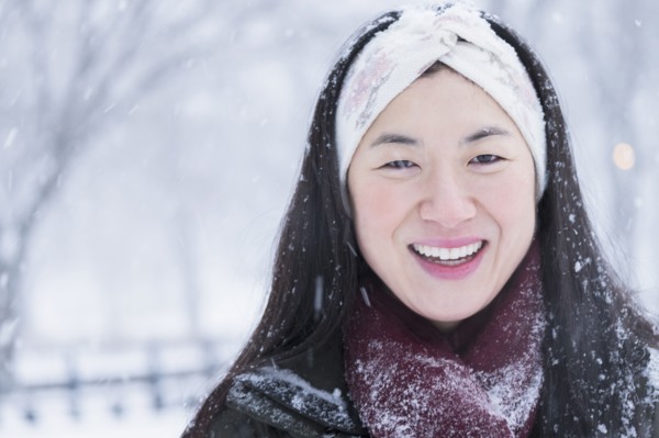 Asian woman smiling in snow