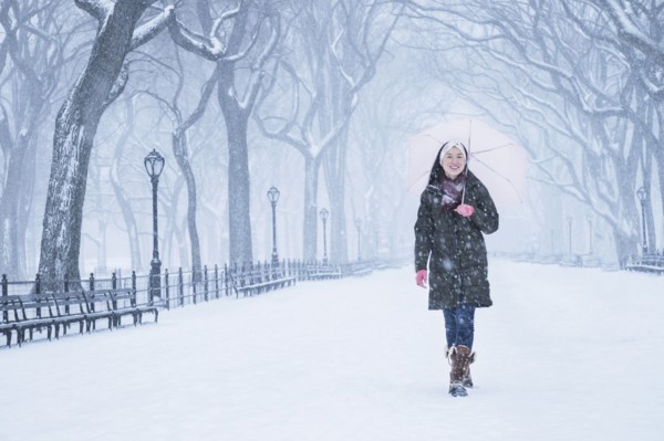 Asian woman walking in snowy Central Park