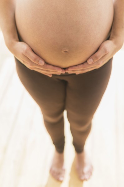 Pregnant Hispanic woman holding her belly