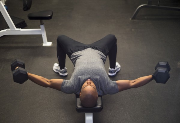 Black man lifting weights in gym