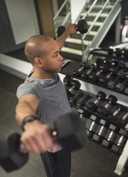 Black man lifting weights in gym