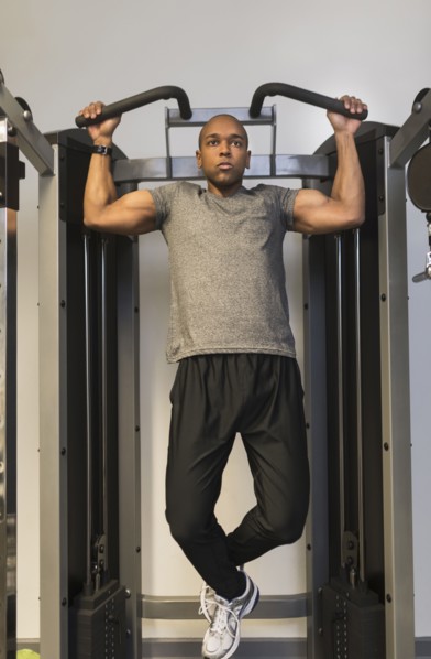 Black man lifting weights in gym