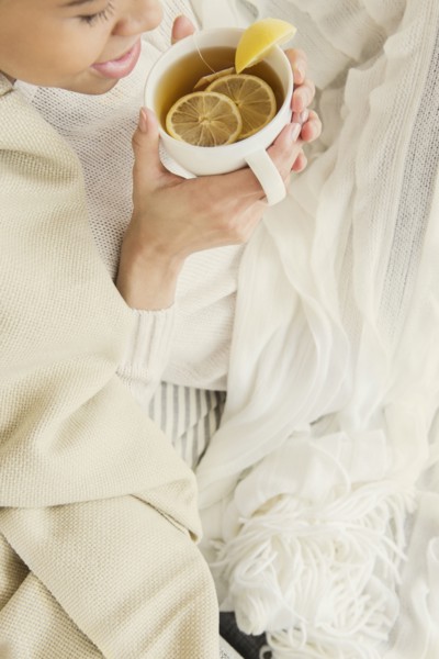 Black woman drinking cup of tea with lemon
