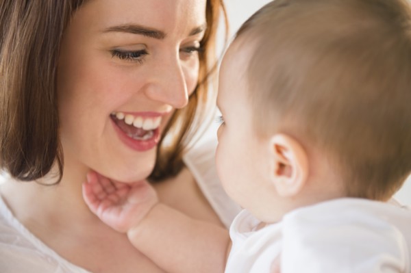 Smiling mother playing with baby
