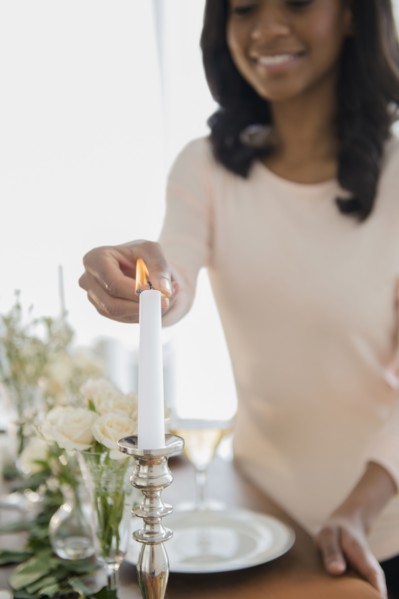 African American woman lighting candle