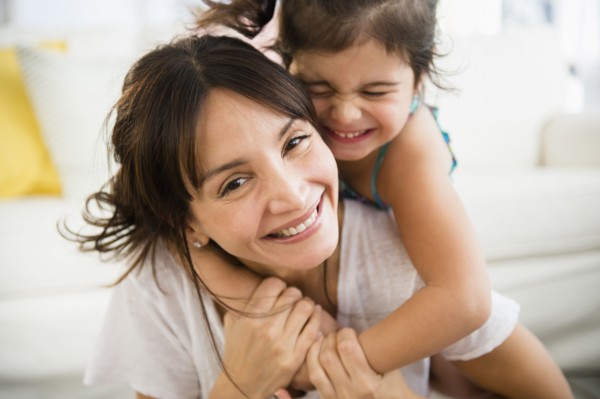 Hispanic mother and daughter playing in living room