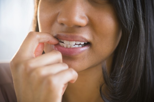 Mixed race woman biting her nail