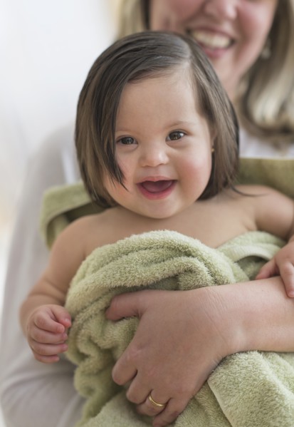 Hispanic mother drying toddler daughter after bath