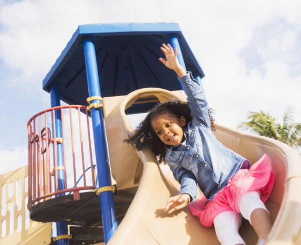 Mixed race girl playing on playground