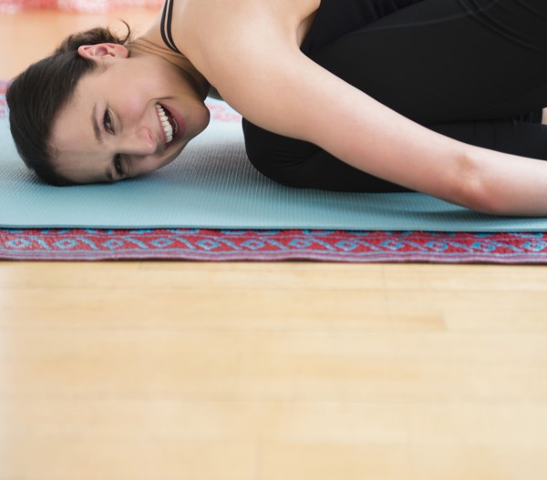 Caucasian woman smiling on yoga mat