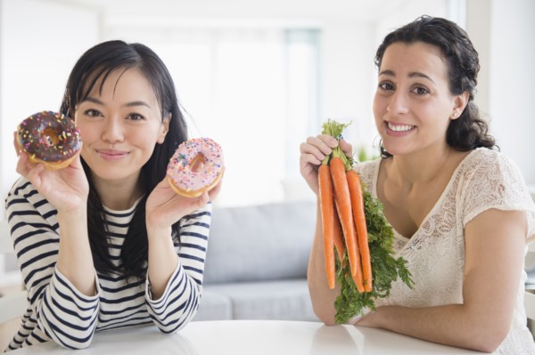 Women choosing between donuts and carrots