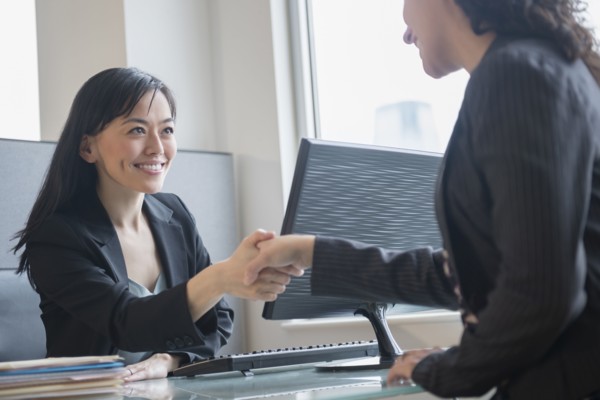 Businesswomen shaking hands in office