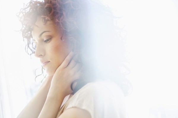Hispanic woman holding chin in hands
