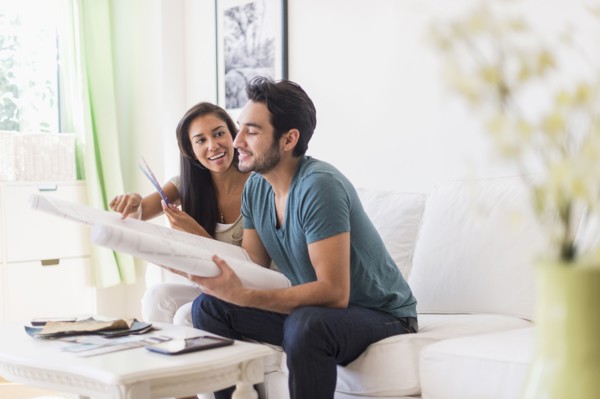Couple examining blueprints in living room